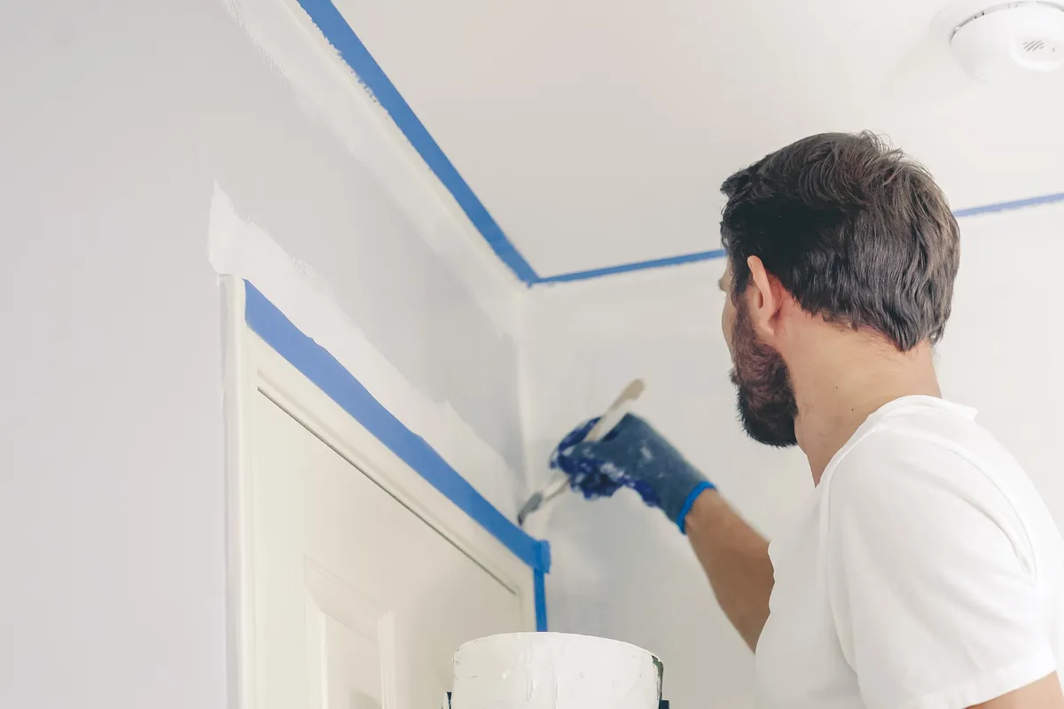 Painter cutting a clean ceiling line by hand